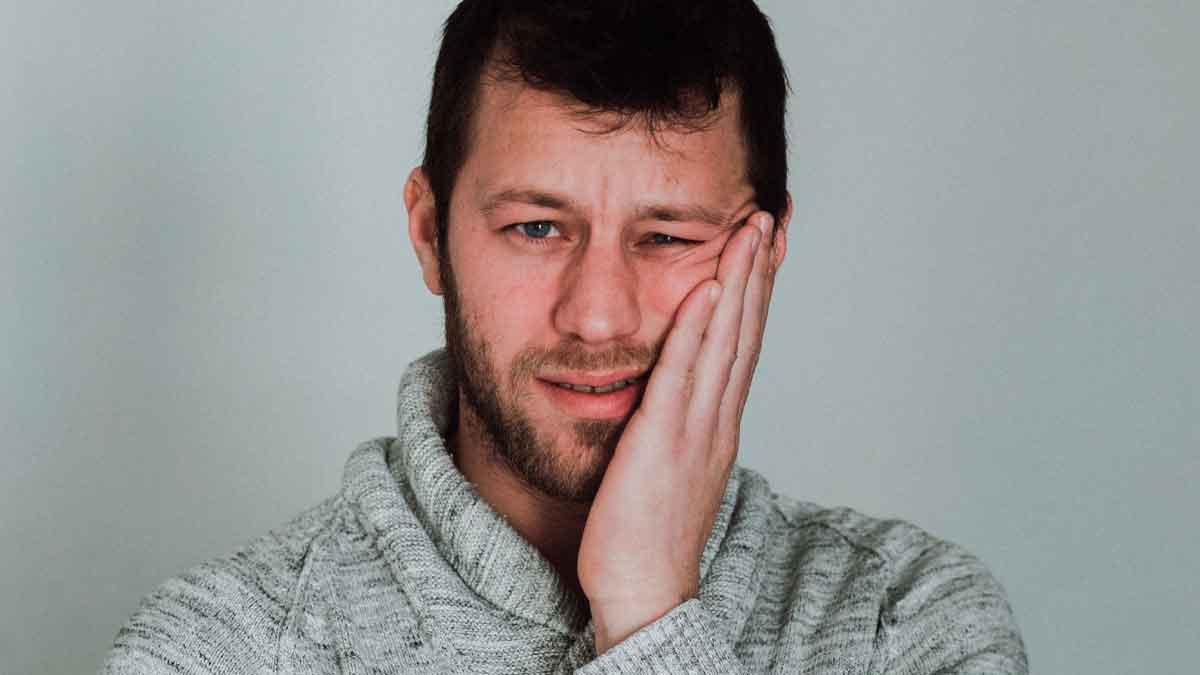Hombre preocupado sosteniendo la mejilla, ilustrando la inquietud de perder el paro por infracciones del SEPE
