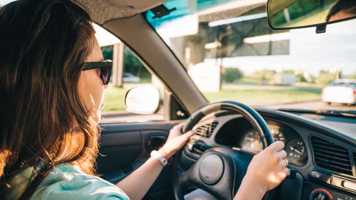 Mujer conduciendo un coche al atardecer, ejemplo de vehículo de gasolina, diésel o eléctrico y su vida útil sin averías