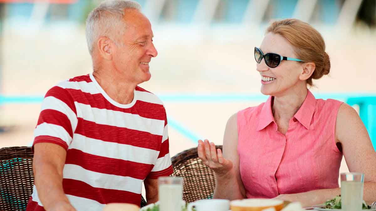Pareja de jubilados europeos conversando relajadamente en una terraza, representando el ranking de pensiones más altas y bajas de Europa