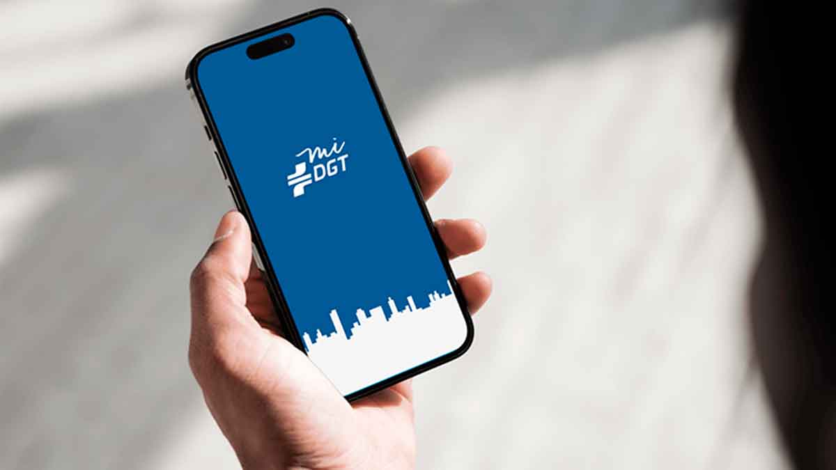 Teléfono móvil con la pantalla de la app miDGT que muestra el carné de conducir digital y agiliza 14 trámites online