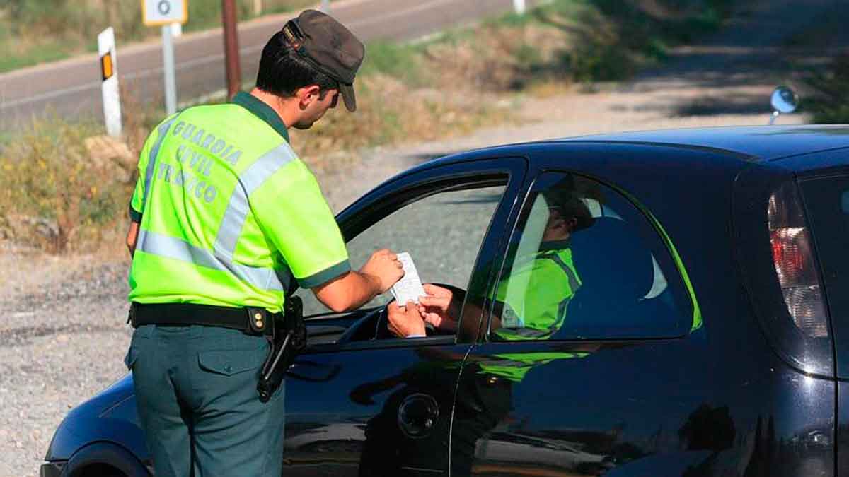 Agente de la Guardia Civil multando a un conductor por ocupar plaza reservada a coches eléctricos