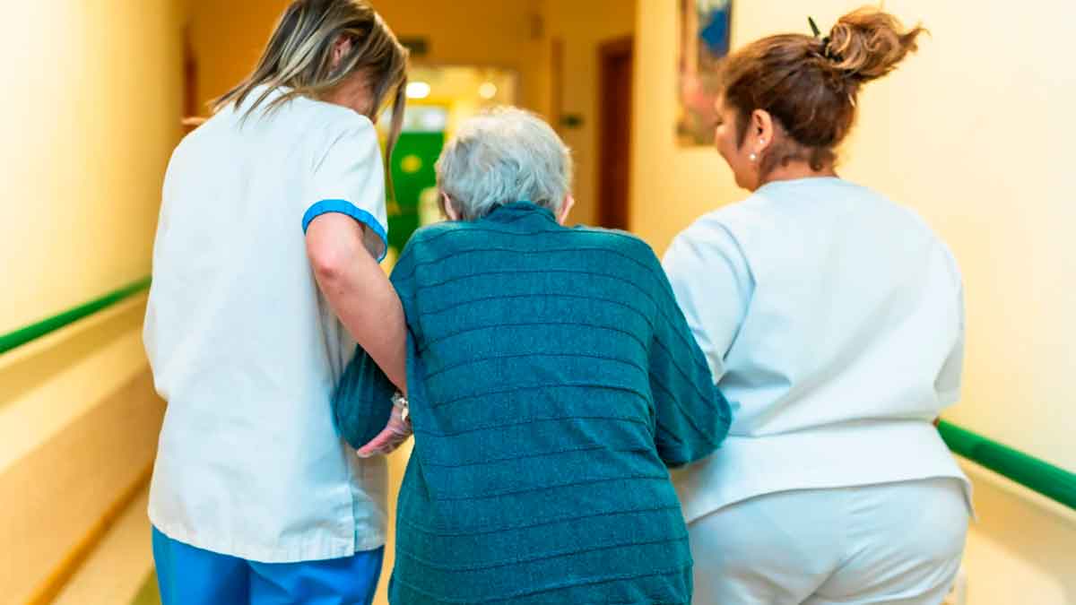 Trabajadores asistiendo a una persona mayor en una residencia de Andalucía