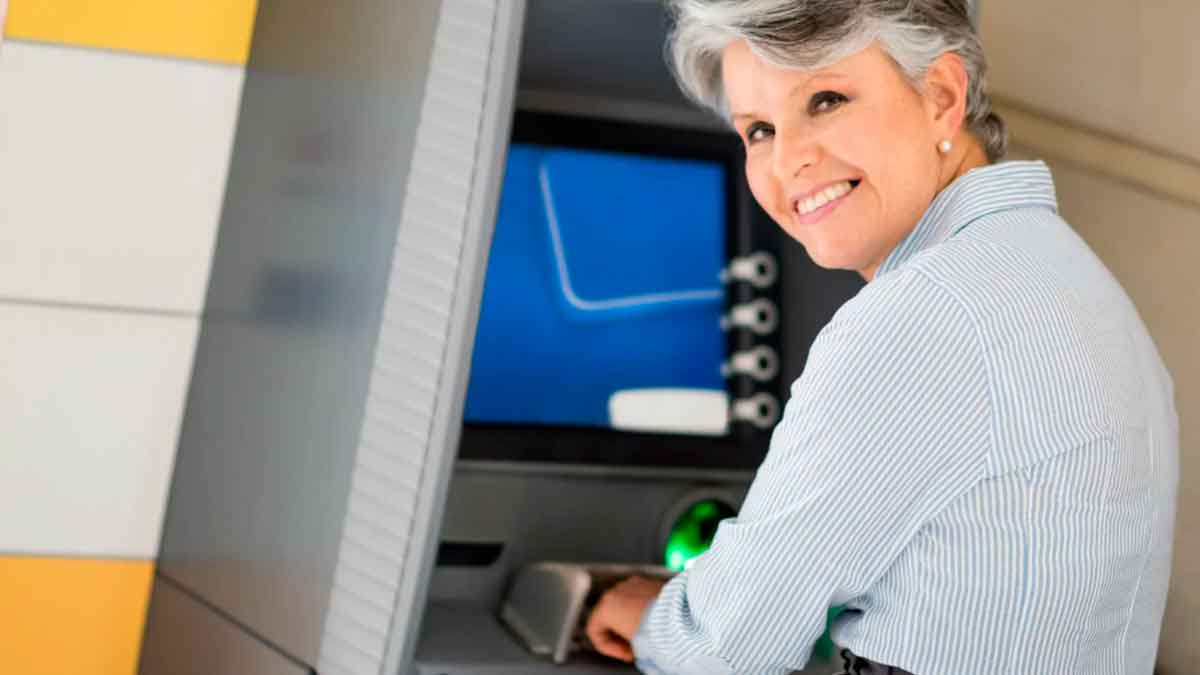 Mujer pensionista retira dinero del cajero tras el adelanto de la paga extra de Navidad de la TGSS