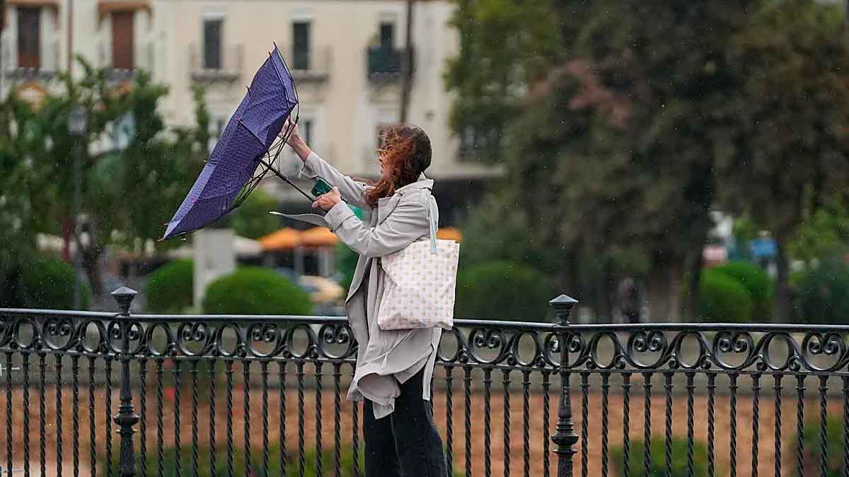 Persona caminando bajo la lluvia y el viento en Andalucía durante un episodio de inestabilidad previo a la Navidad