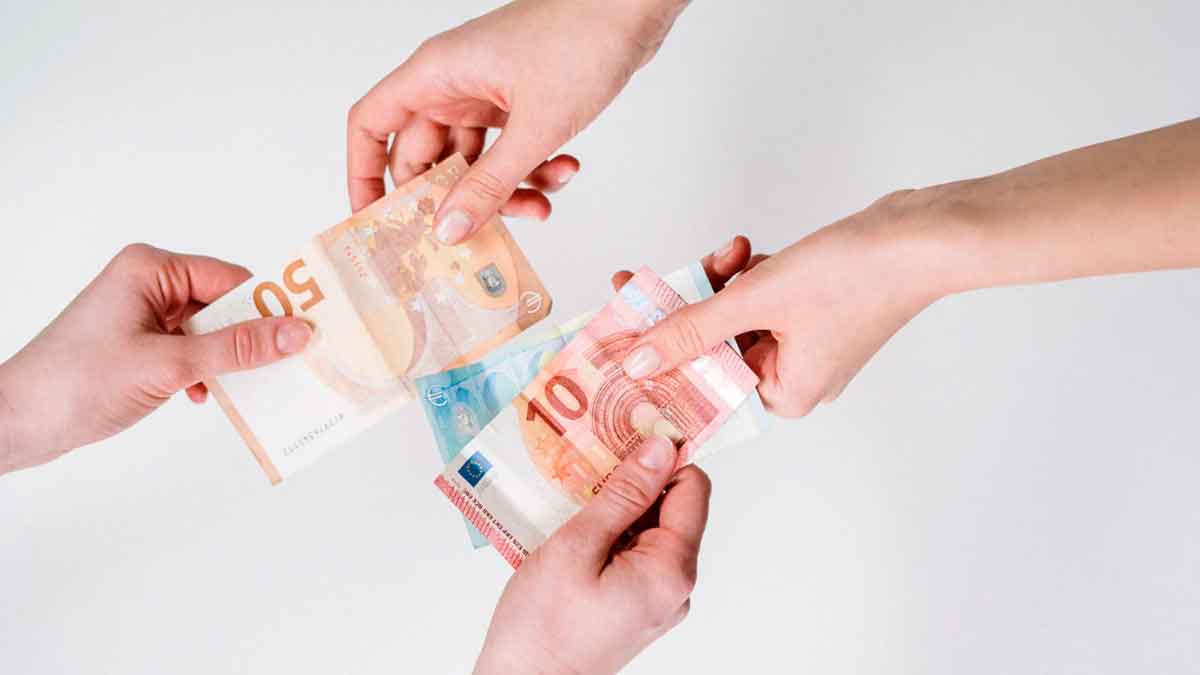 Manos intercambiando billetes de euro en una transferencia de dinero entre familiares