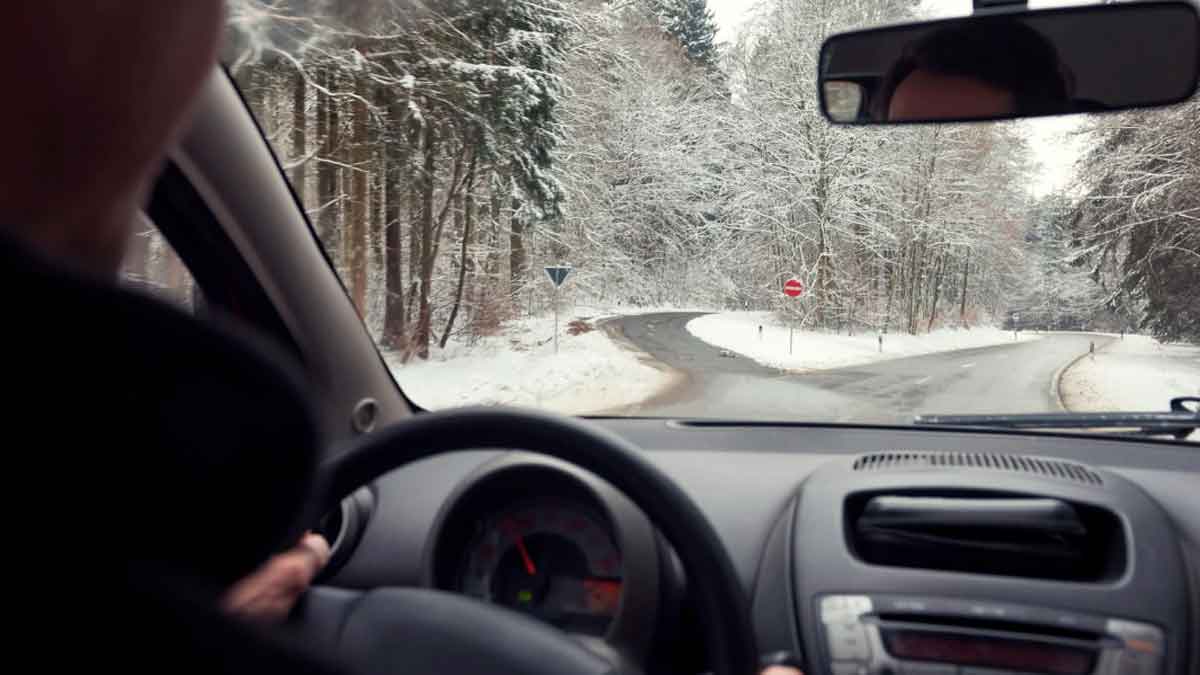 Conductor circulando por una carretera nevada durante controles de invierno de la DGT