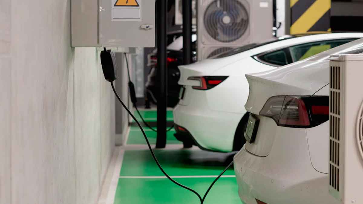 Coches eléctricos cargando en un garaje privado con deducción del 15% en el IRPF en 2026