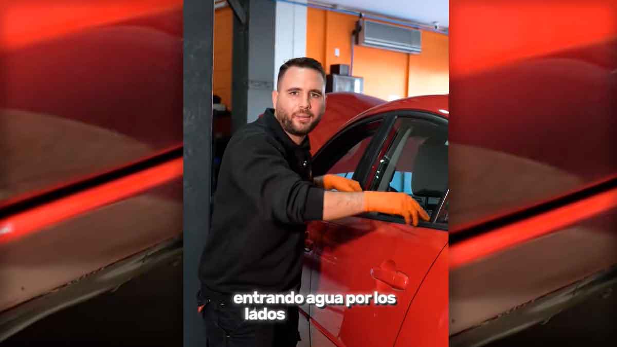 Mecánico revisando la entrada de agua en la puerta de un coche por desagües atascados durante la temporada de lluvias