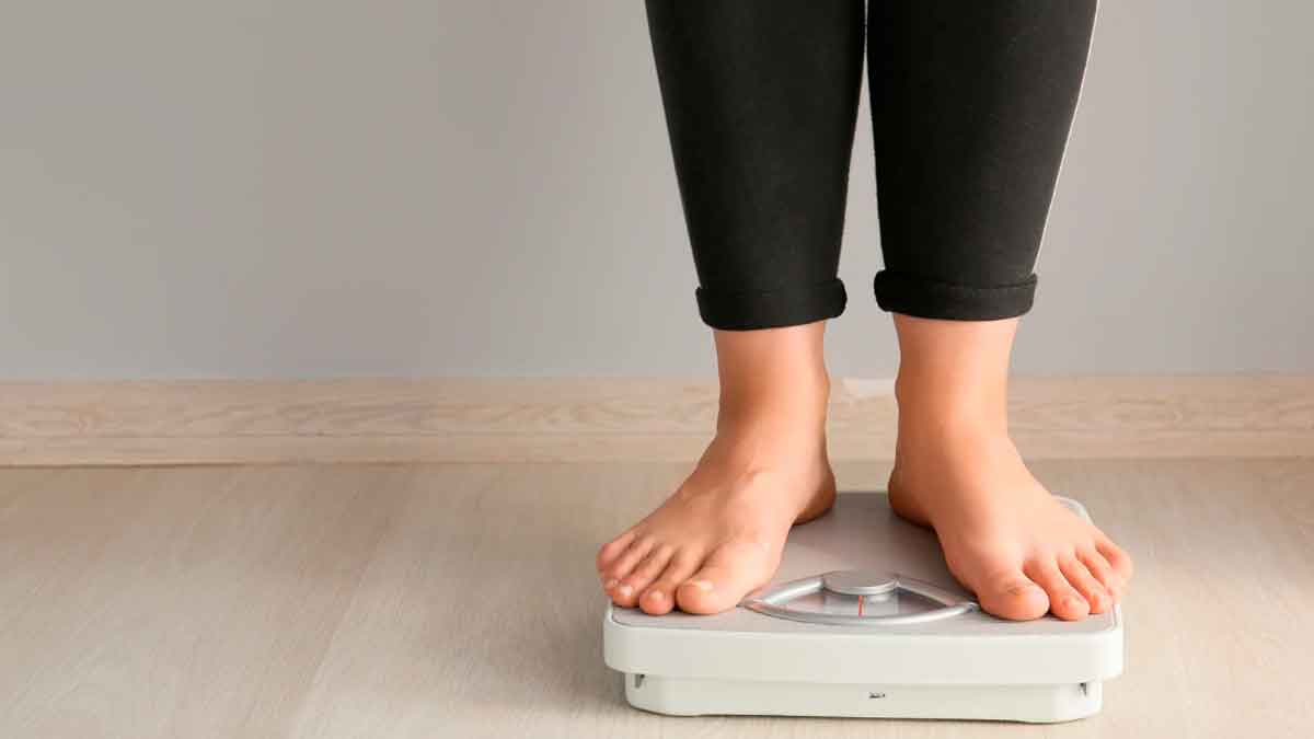 Persona subida a una báscula de baño preocupada por el peso tras seguir dietas milagro