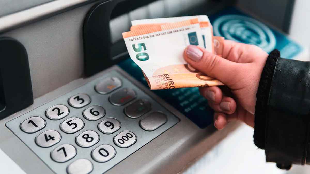 Persona sacando dinero de un cajero automático por el cobro del paro en enero de 2026
