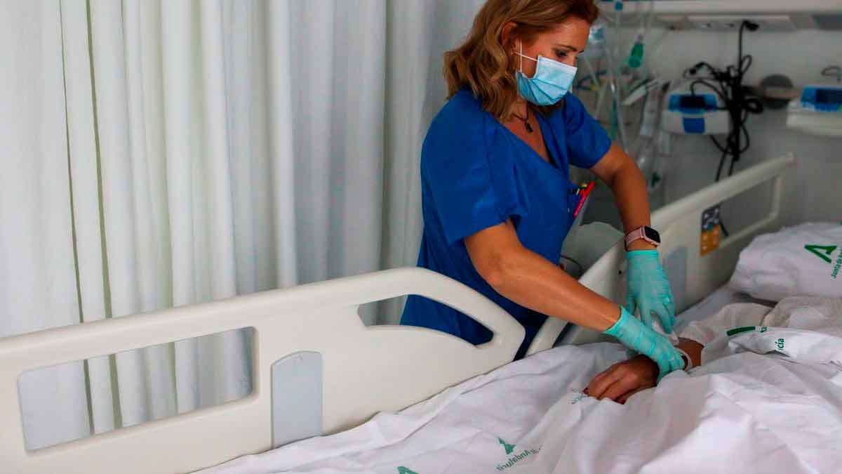 Profesional sanitaria atiende a un paciente hospitalizado en un centro del Servicio Andaluz de Salud