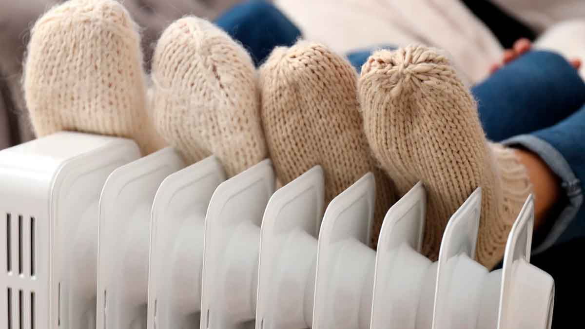 Familia calentándose en casa con radiador gracias a la ayuda de 3.000 euros para mejorar la calefacción en 2026