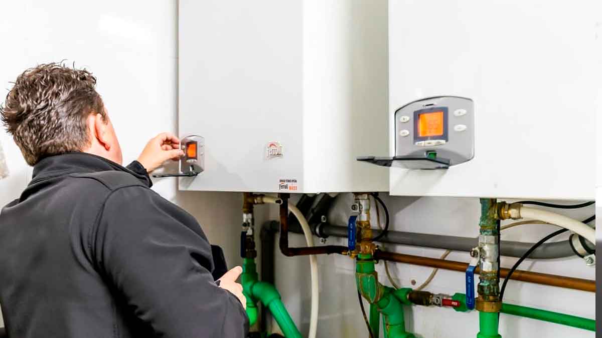 Técnico revisando una caldera en una vivienda de alquiler tras una avería