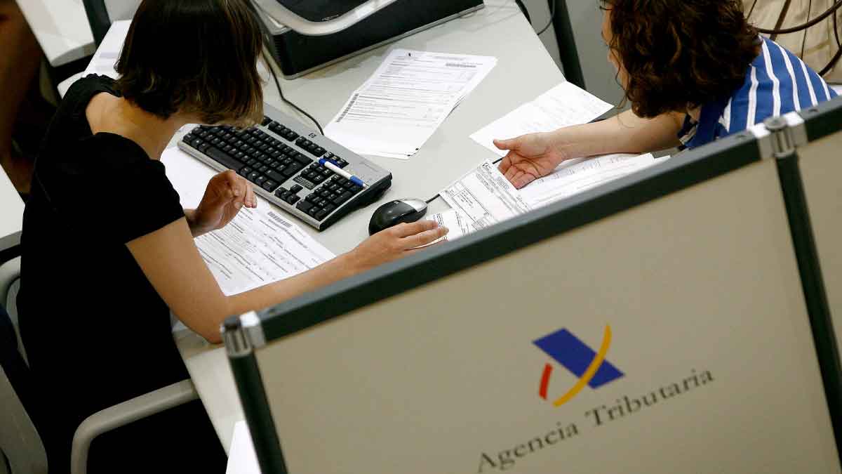 Contribuyentes revisando una declaración de la Renta en una oficina de la Agencia Tributaria