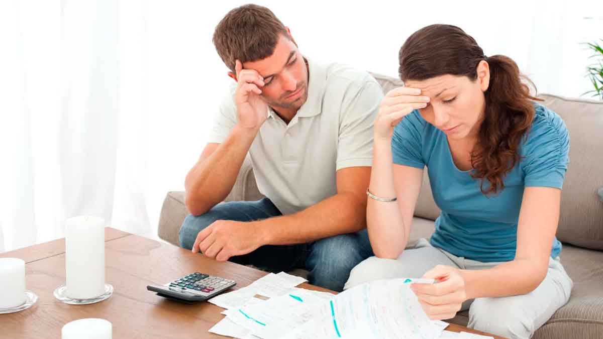 Pareja revisando facturas y gastos del hogar durante la cuesta de enero para mejorar el ahorro familiar