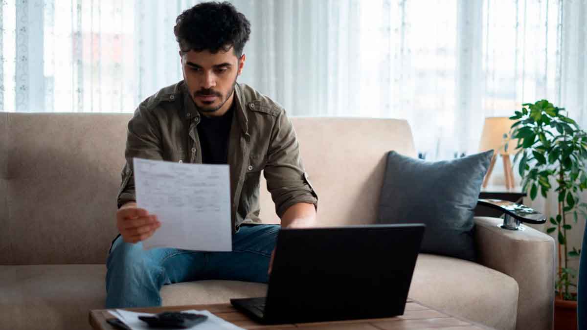 Joven revisando documentos en casa al conocer las consecuencias fiscales de vivir sin pagar alquiler en la vivienda de sus padres