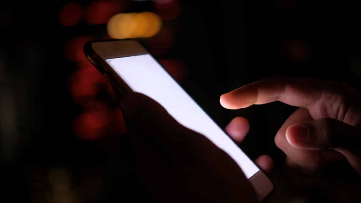 Persona utilizando un smartphone en un entorno oscuro como símbolo de riesgo de estafas digitales
