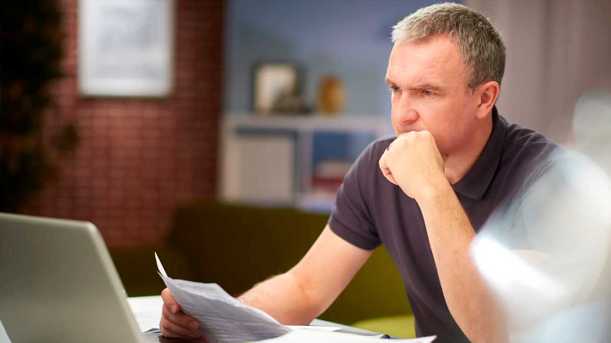 Hombre revisando documentación sobre el subsidio del SEPE para mayores de 52 años