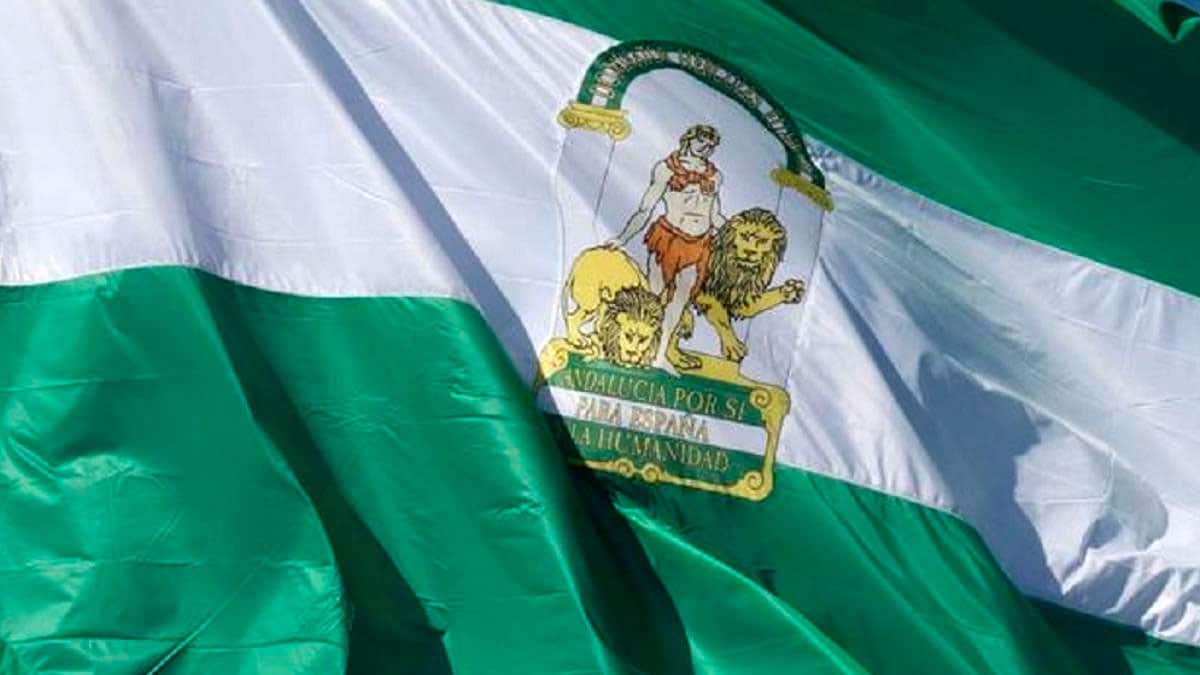 Bandera de Andalucía ondeando con el escudo oficial durante la celebración del 28F