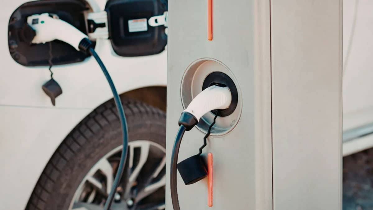 Coche eléctrico cargando en un punto de recarga ultrarrápida en una área de servicio