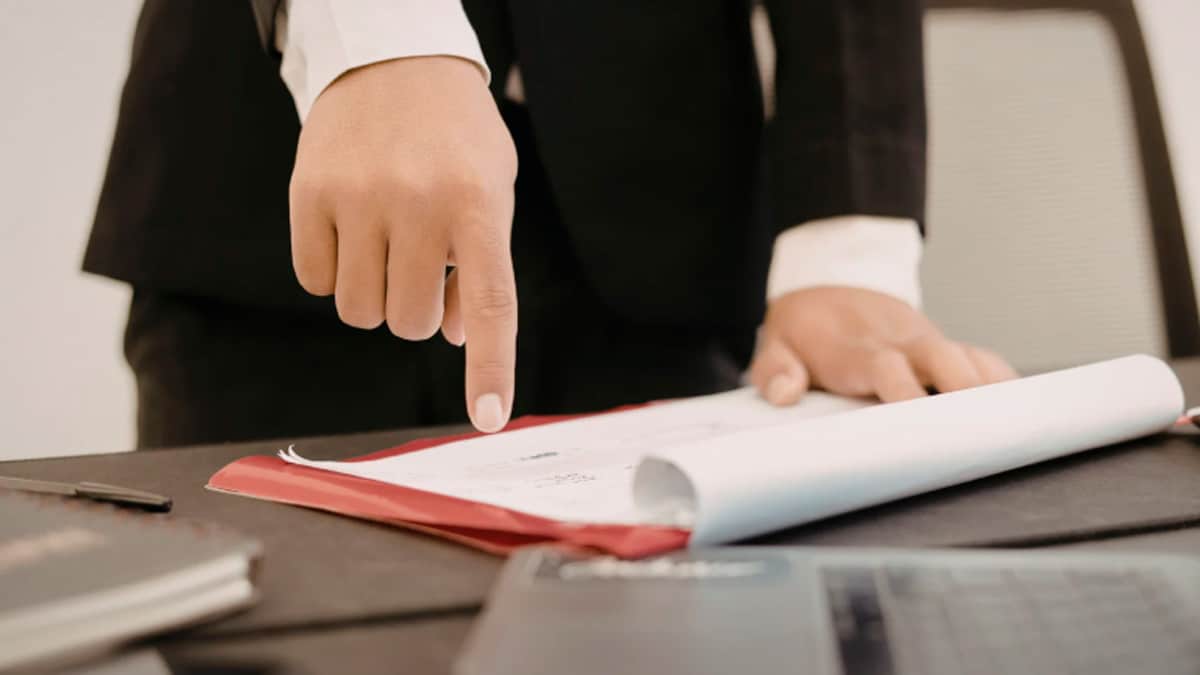 Trabajador señalando un contrato laboral para solicitar autodespido con derecho a paro e indemnización