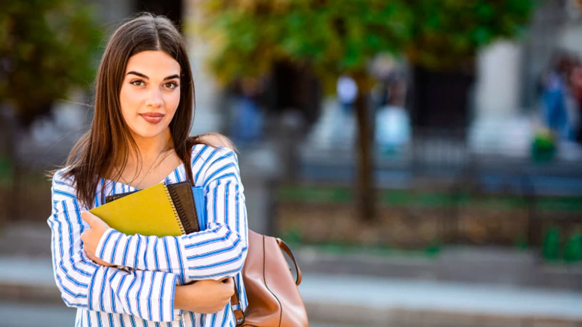 Estudiante universitaria con libros beneficiaria de ayudas UNIVERGEM 2025/2026 en Andalucía