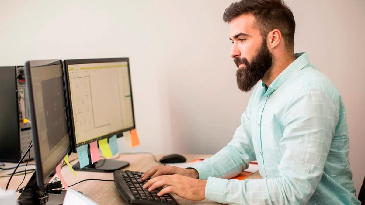 Trabajador usando un ordenador de empresa en su puesto de trabajo