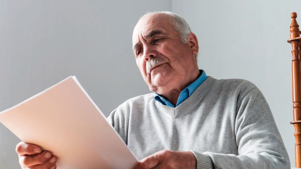 Hombre mayor revisando un documento sobre la jubilación anticipada y las penalizaciones en 2026