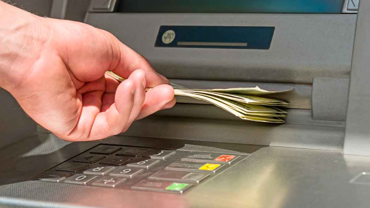 Persona retirando dinero de un cajero automático tras el ingreso del paro en febrero de 2026