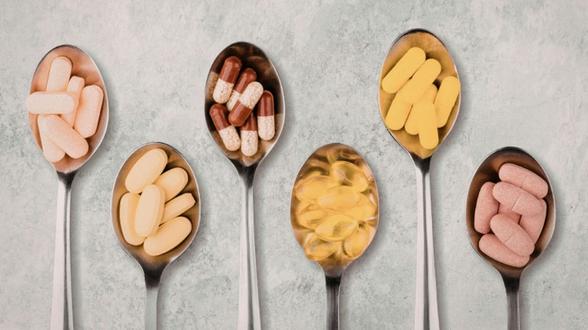 Cucharas con diferentes suplementos dietéticos de moda en cápsulas y comprimidos