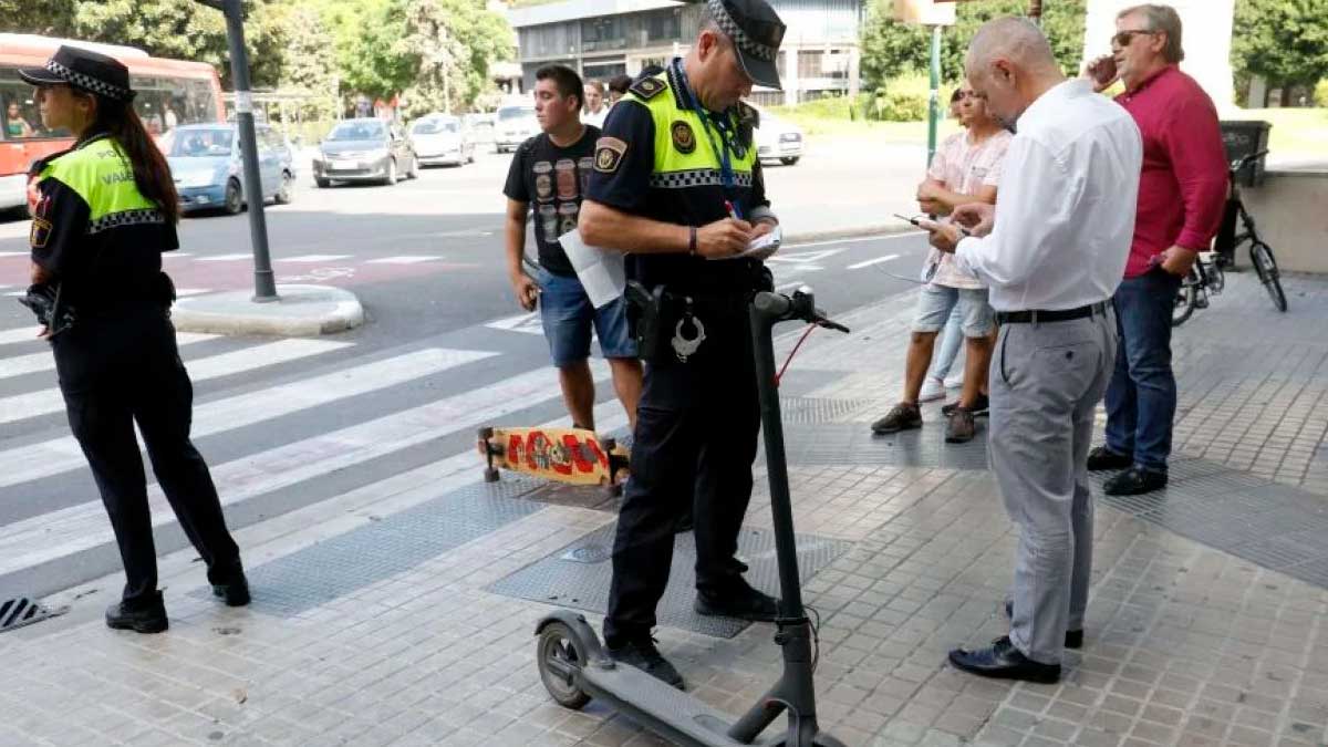 Policía sancionando a un conductor de patinete eléctrico en la vía pública por no tener seguro
