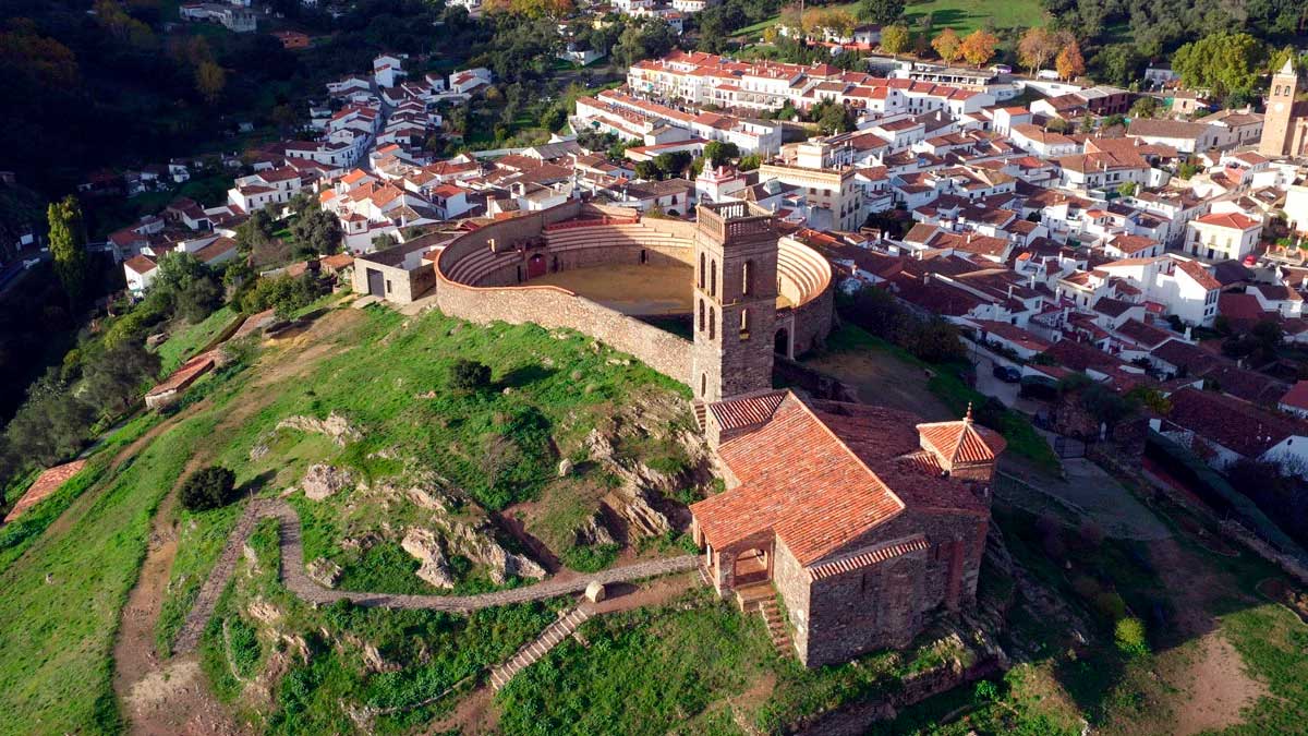 Vista aérea de pueblo blanco en Andalucía con plaza de toros y casco histórico, ideal para escapada rural
