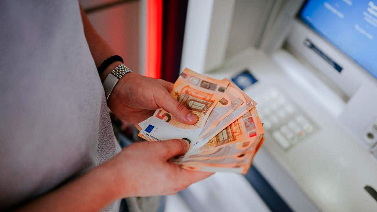 Persona retirando dinero en un cajero automático tras el ingreso de la pensión de febrero de 2026