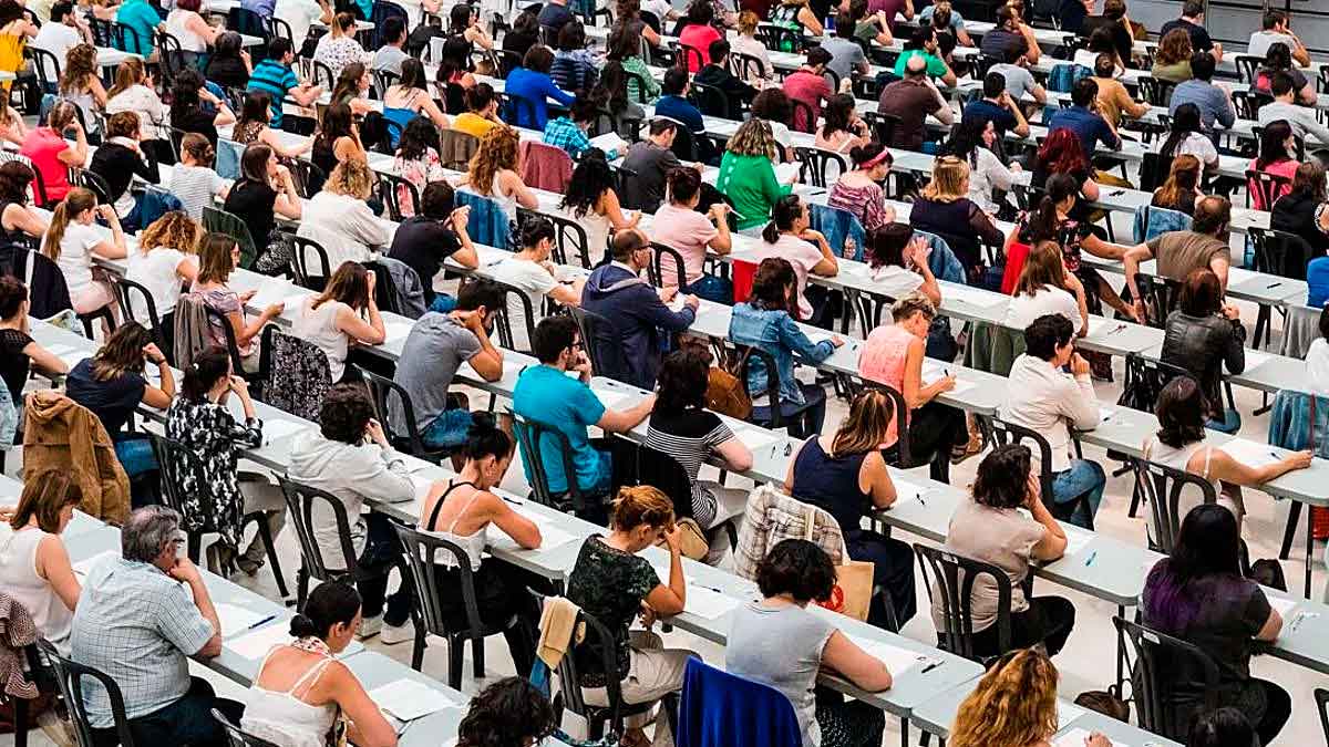 Aspirantes realizando examen de oposiciones en 2026 en un aula con decenas de candidatos