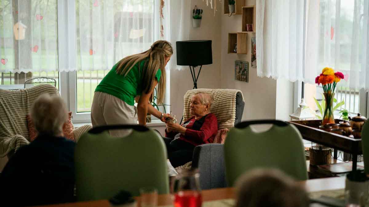 Cuidadora atiende a una persona mayor en una residencia de mayores en Andalucía