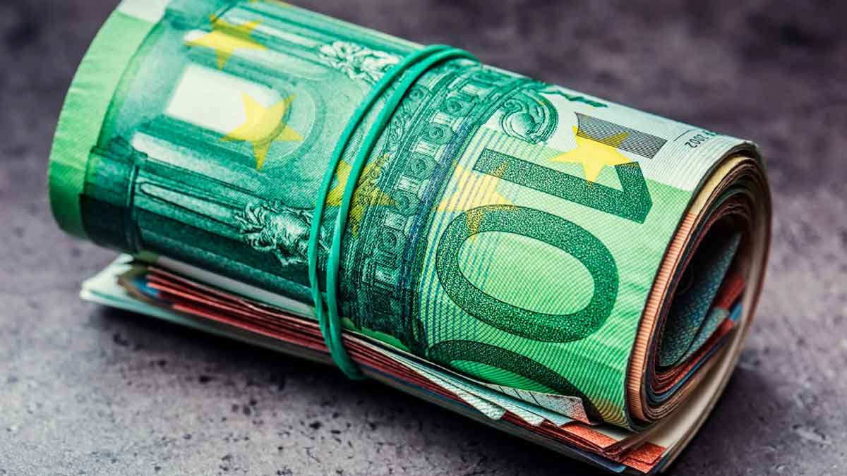 Billetes de euro enrollados que representan el cobro de la nómina en efectivo según la normativa vigente