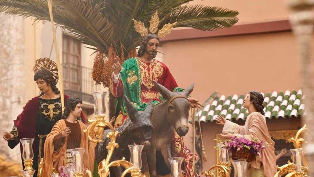 Procesión de Domingo de Ramos en Andalucía con paso de Jesús en burro durante ambiente frío de Semana Santa