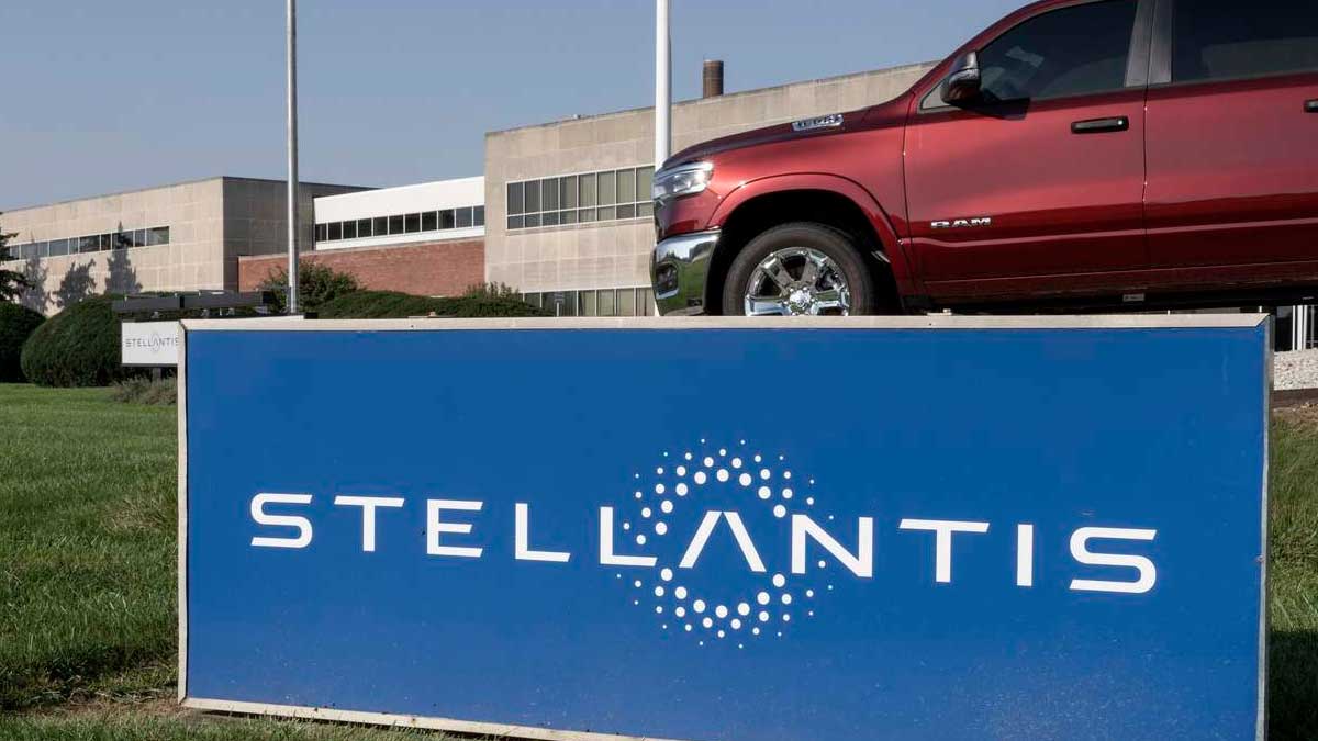 Logo de Stellantis en sede con coche afectado por riesgo de incendio en modelos gasolina microhíbridos