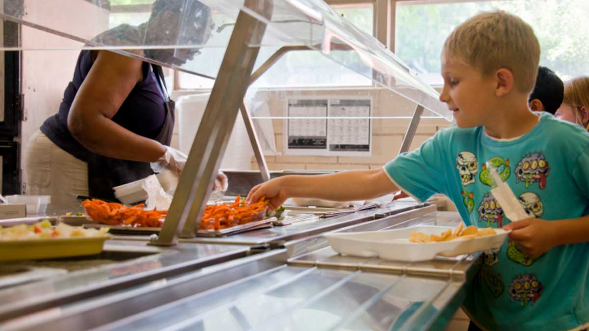 niño recogiendo comida en un comedor escolar en Andalucía durante el servicio de comedor en un colegio público