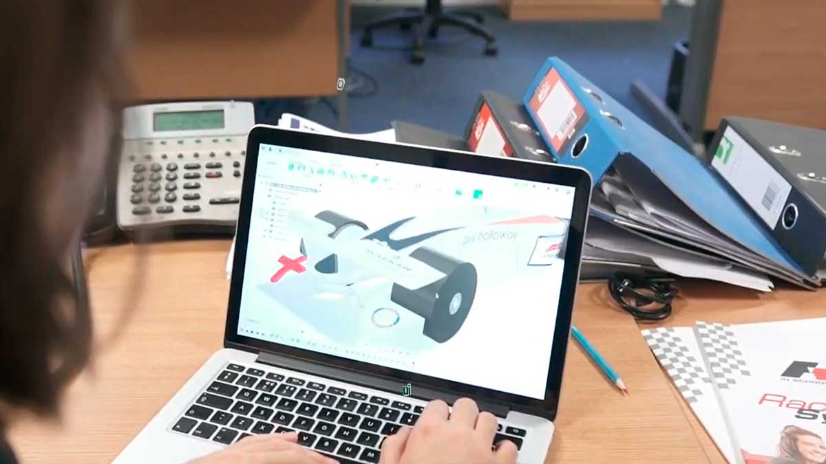 Estudiante diseñando un coche de Fórmula 1 en miniatura con software CAD durante el programa educativo STEM Racing en Andalucía