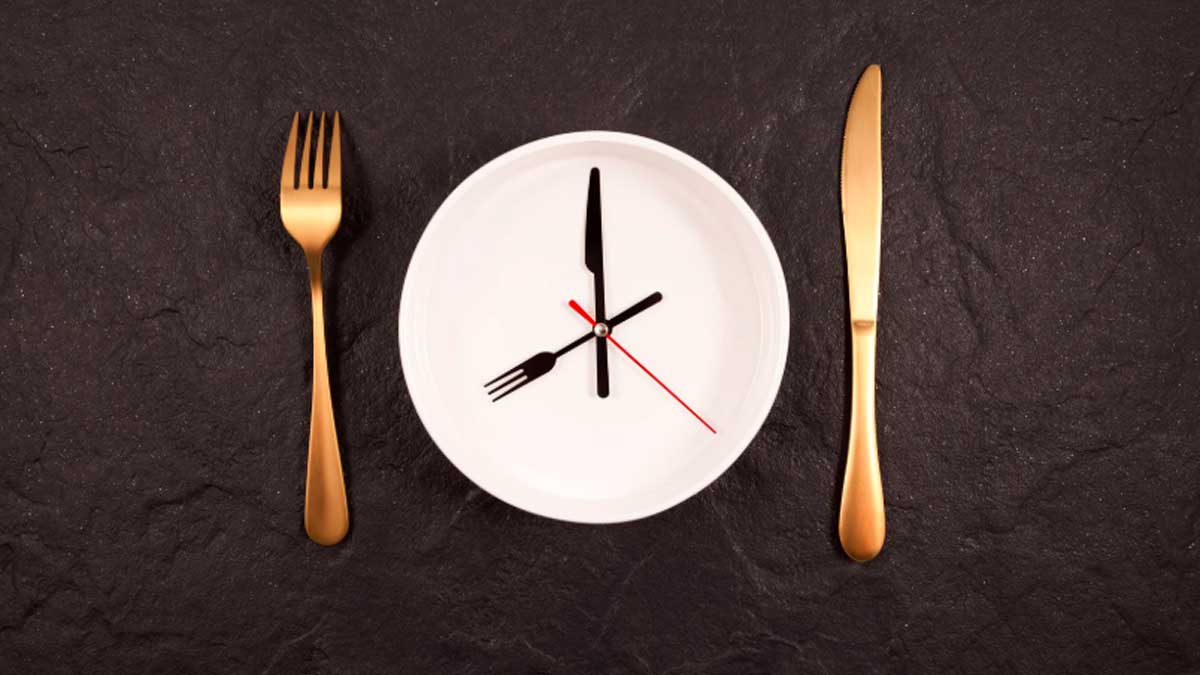 Reloj en plato simbolizando ayuno y proceso de autofagia