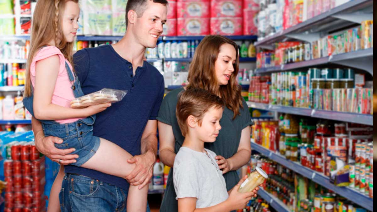 Familia con hijos comprando alimentos en supermercado ayudas familiares 2026