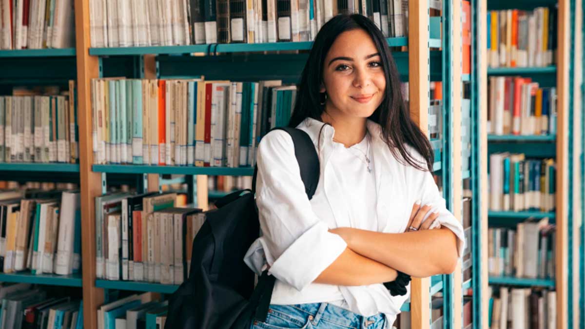 Estudiante universitaria en biblioteca consultando información sobre Becas MEC 2026-2027