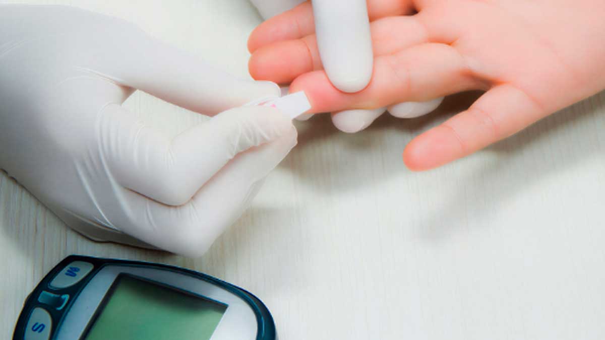 Medición de azúcar en sangre con glucómetro tras un pinchazo en el dedo