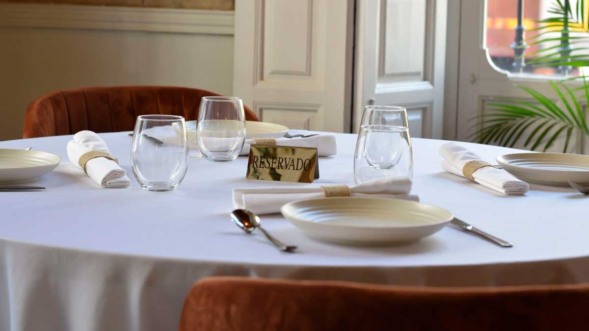 Mesa de restaurante con cartel de reservado en Andalucía y vajilla preparada