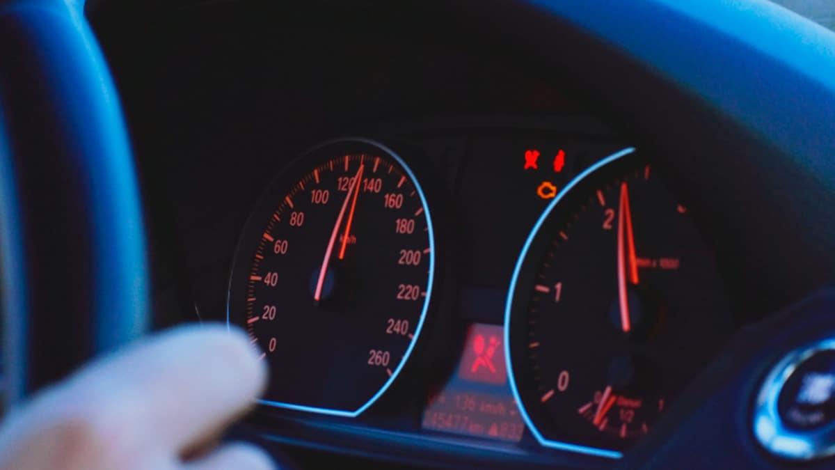 Velocímetro marcando alta velocidad en un coche por exceso de velocidad en carretera