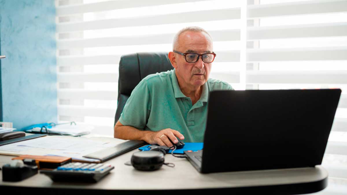Hombre mayor trabajando con portátil tras jubilarse en España jubilación activa 2026