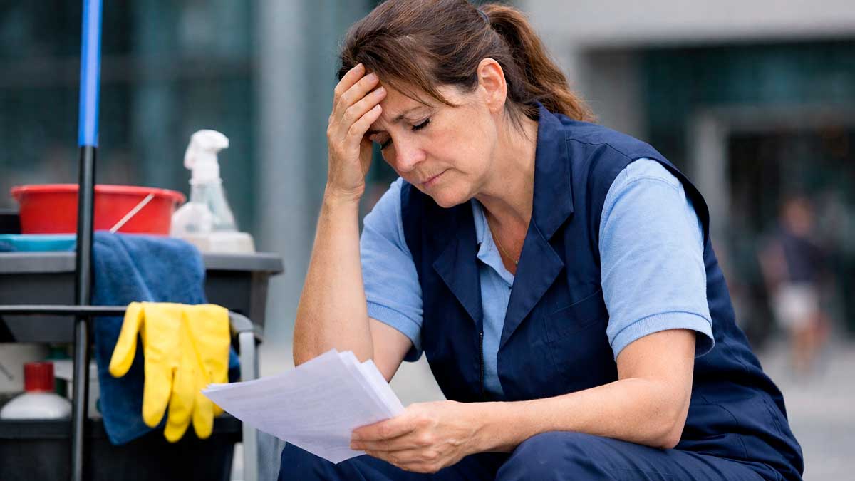 Limpiadora revisa documentos tras su despido después de un año y medio de baja laboral