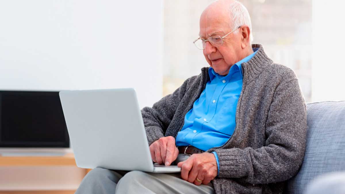 Pensionista revisando su cuenta en el ordenador mientras espera la devolución del IRPF de Hacienda para mutualistas jubilados