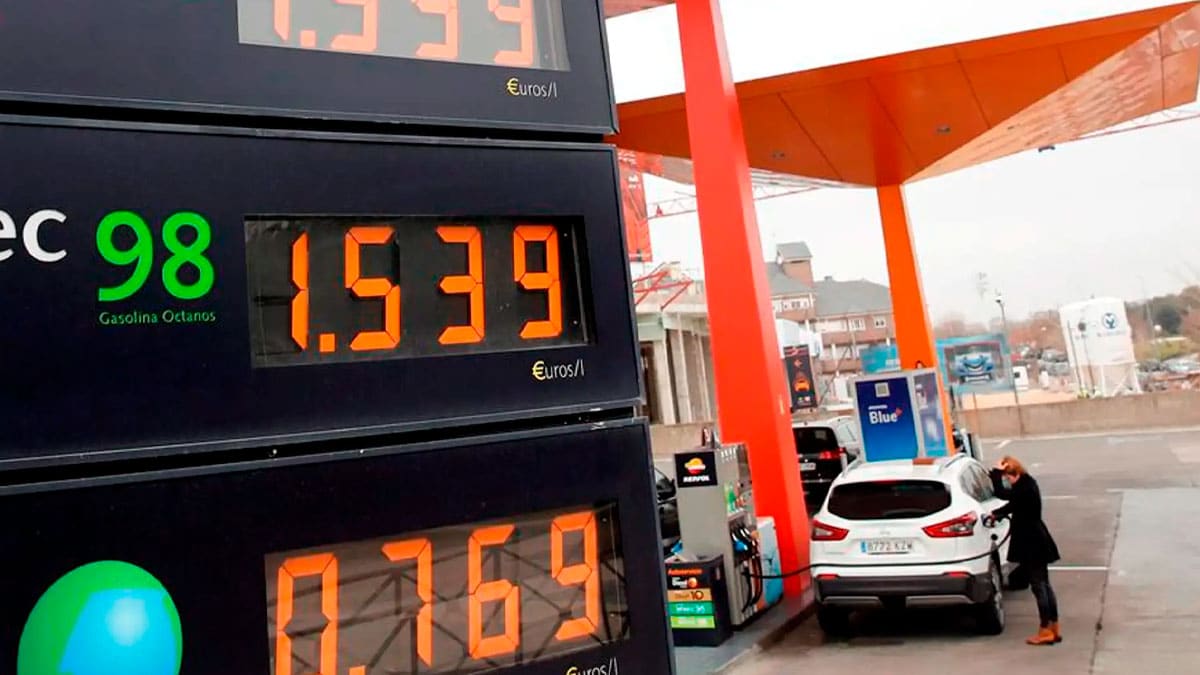 Panel de precios en una gasolinera con gasolina 98 a 1,539 euros por litro mientras un coche reposta combustible